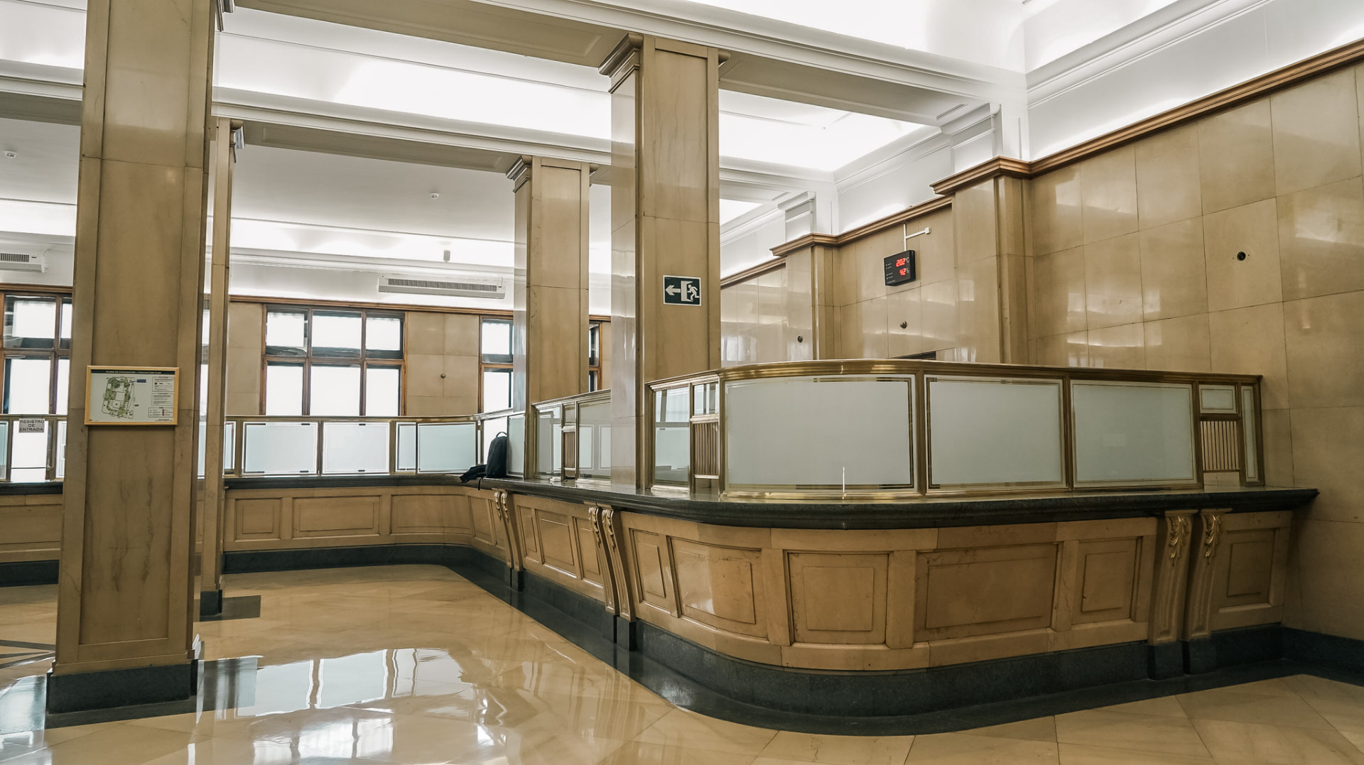 Vestíbulo institucional con mostrador de mármol y columnas